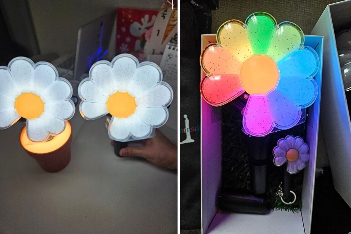 Chiếc lightstick có hình dáng một bông hoa cúc trắng với nhụy vàng, đi kèm phần thân cây và lá, tạo cảm giác như một bông hoa thật.