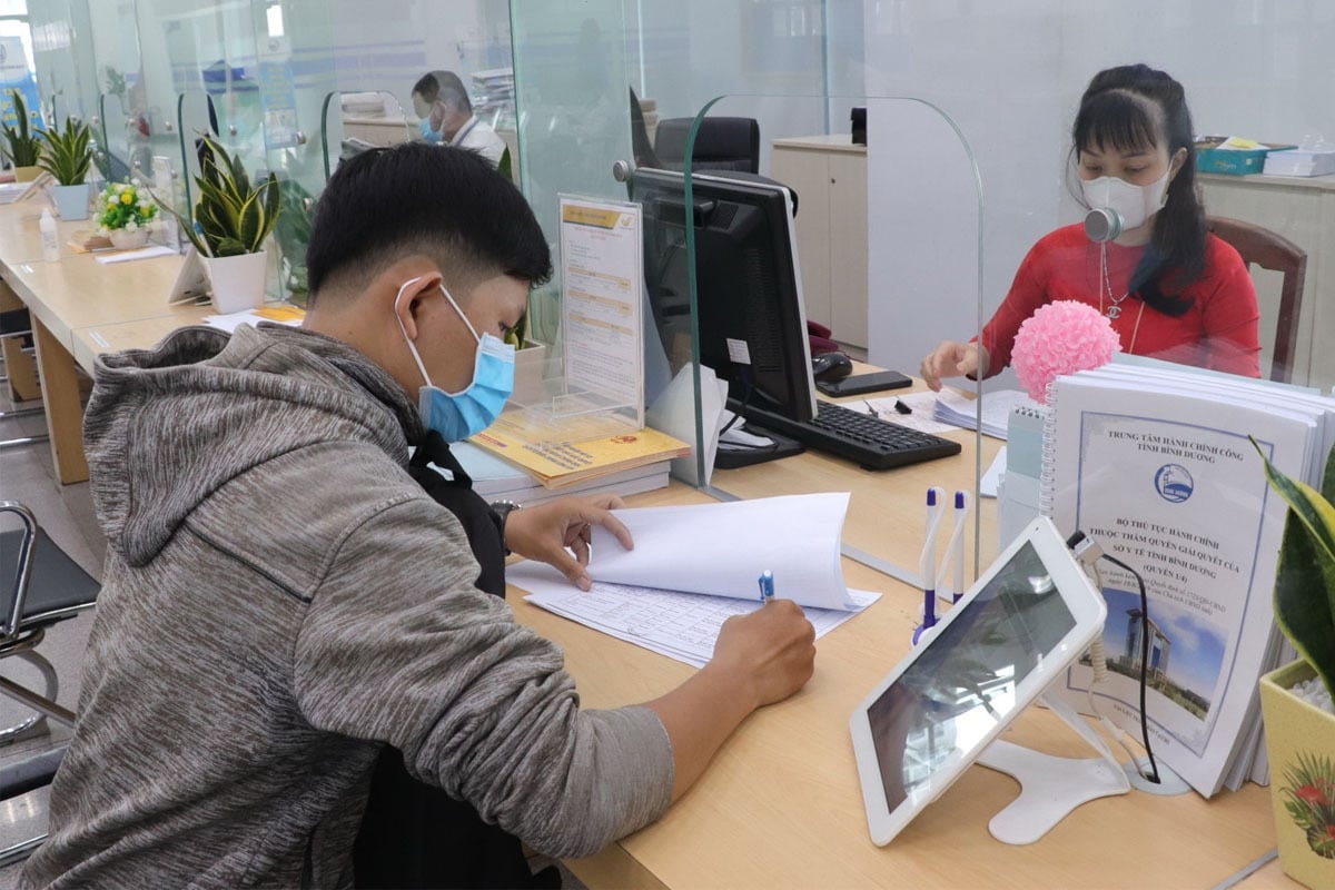 Cán bộ tỉnh Bình Dương hỗ trợ người dân giải quyết thủ tục hành chính. (Ảnh: Báo Bình Dương)
