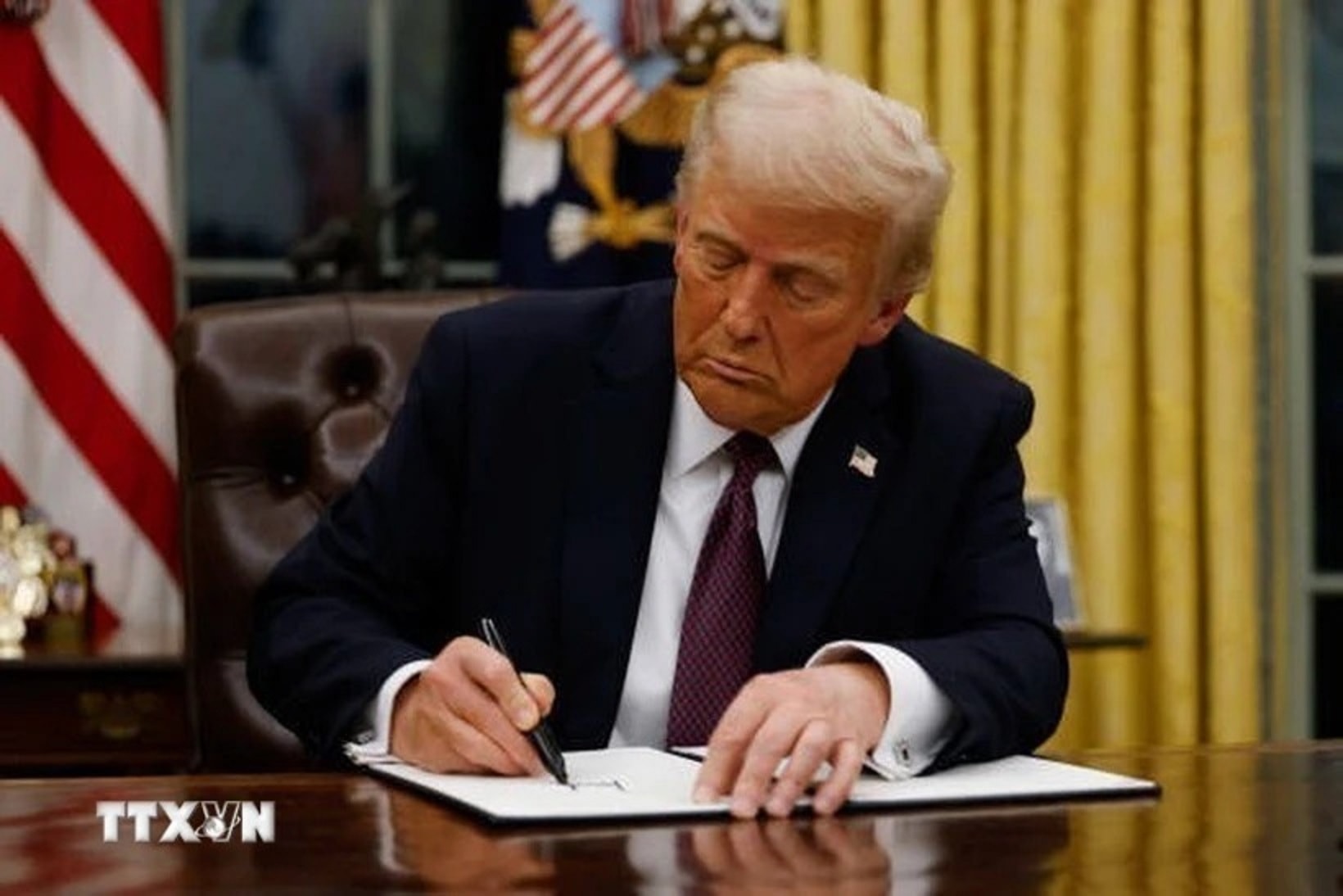 Tổng thống Mỹ Donald Trump ký một sắc lệnh tại Nhà Trắng, Washington D.C. (Ảnh: Getty Images/TTXVN)