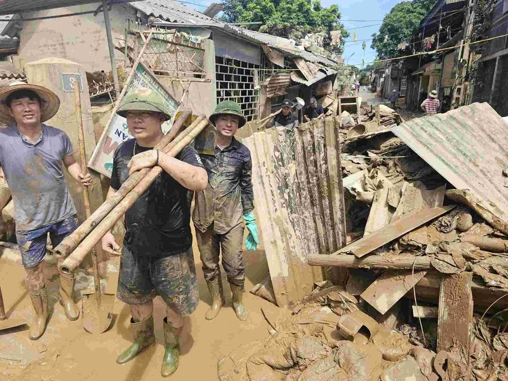 Các thầy cô giáo miền xuôi mang theo cuốc, xẻng lên hỗ trợ dọn dẹp bùn đất ở các trường học miền núi. (Ảnh: CTV)