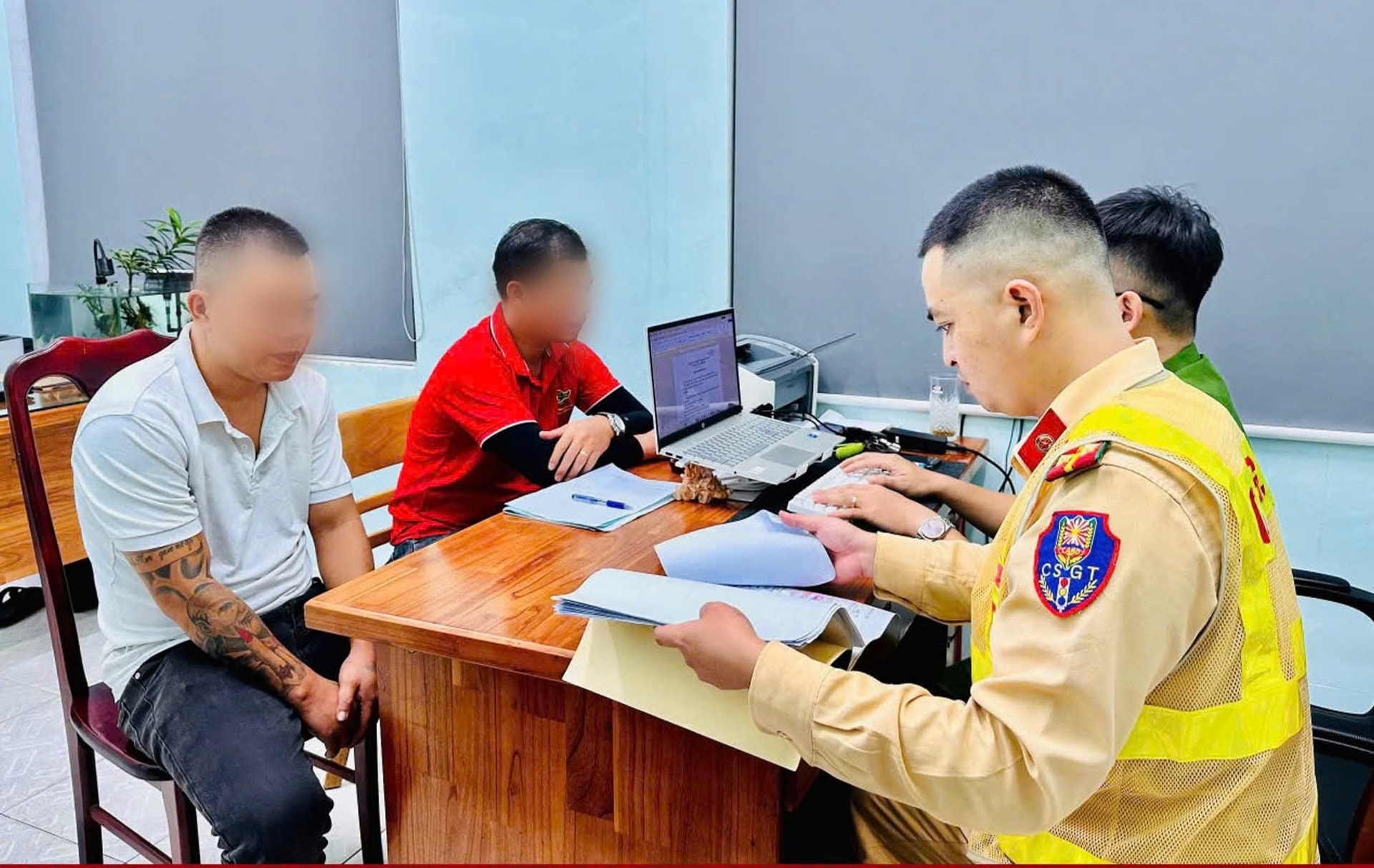 Lực lượng CSGT làm việc với phụ xe (áo đỏ) - người ngồi giữa Quốc lộ, chặn đầu xe khác. (Ảnh: CA)