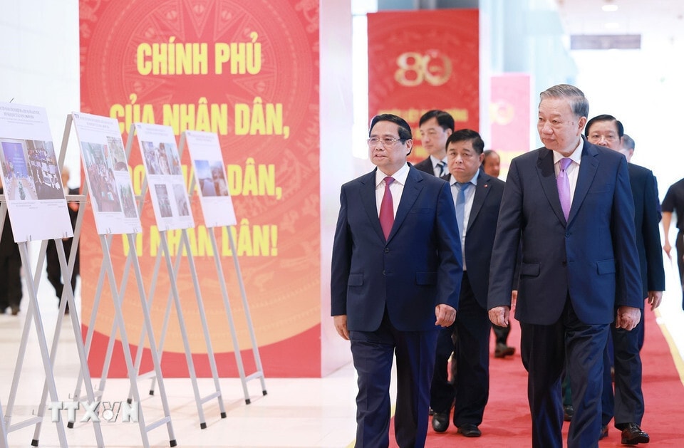 Tổng Bí thư Tô Lâm và Thủ tướng Phạm Minh Chính cùng các đại biểu tham quan trưng bày ảnh về hoạt động của Chính phủ qua các thời kỳ do TTXVN thực hiện. (Ảnh: Dương Giang/TTXVN)