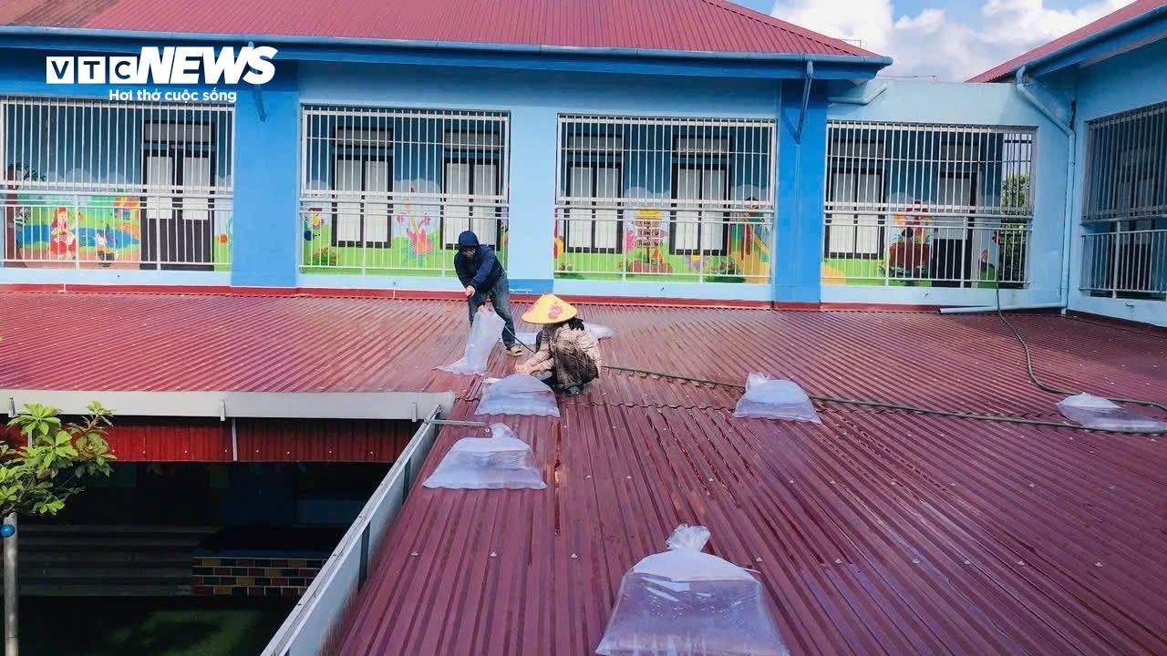 Người dân Hà Tĩnh bơm nước vào các túi nilong để gia cố mái nhà, trường học. (Ảnh: Thế Anh)