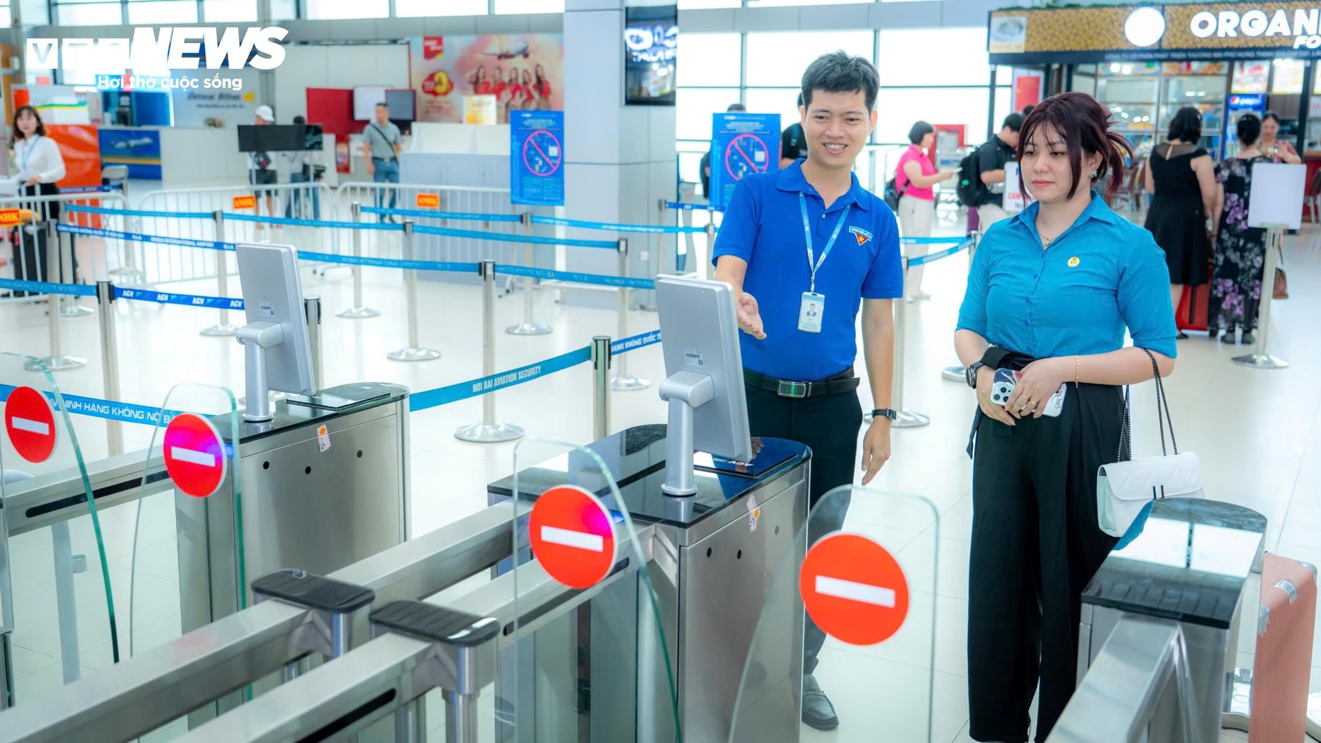 Lực lượng thanh niên tình nguyện hỗ trợ hướng dẫn hành khách thực hiện check-in online bằng ứng dụng VNeID tại sân bay Nội Bài.