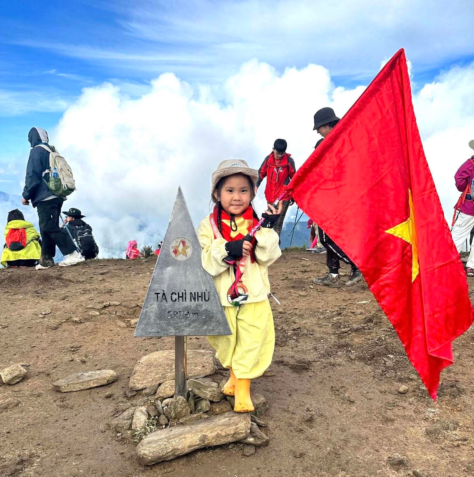 Bé Bơ phất cao lá cờ Việt Nam trên đỉnh Tà Chì Nhù.