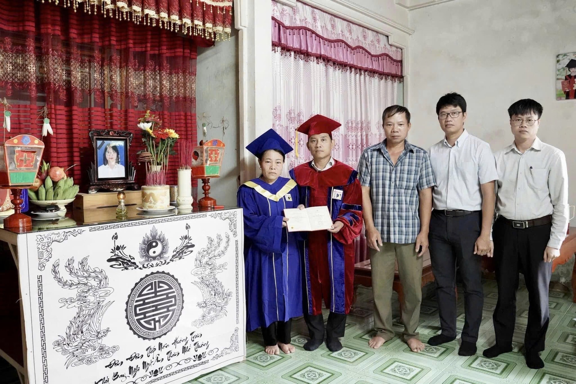 Mẹ của Trà khoác áo cử nhân, nhận bằng tốt nghiệp thay con. (Ảnh: Đ.H)