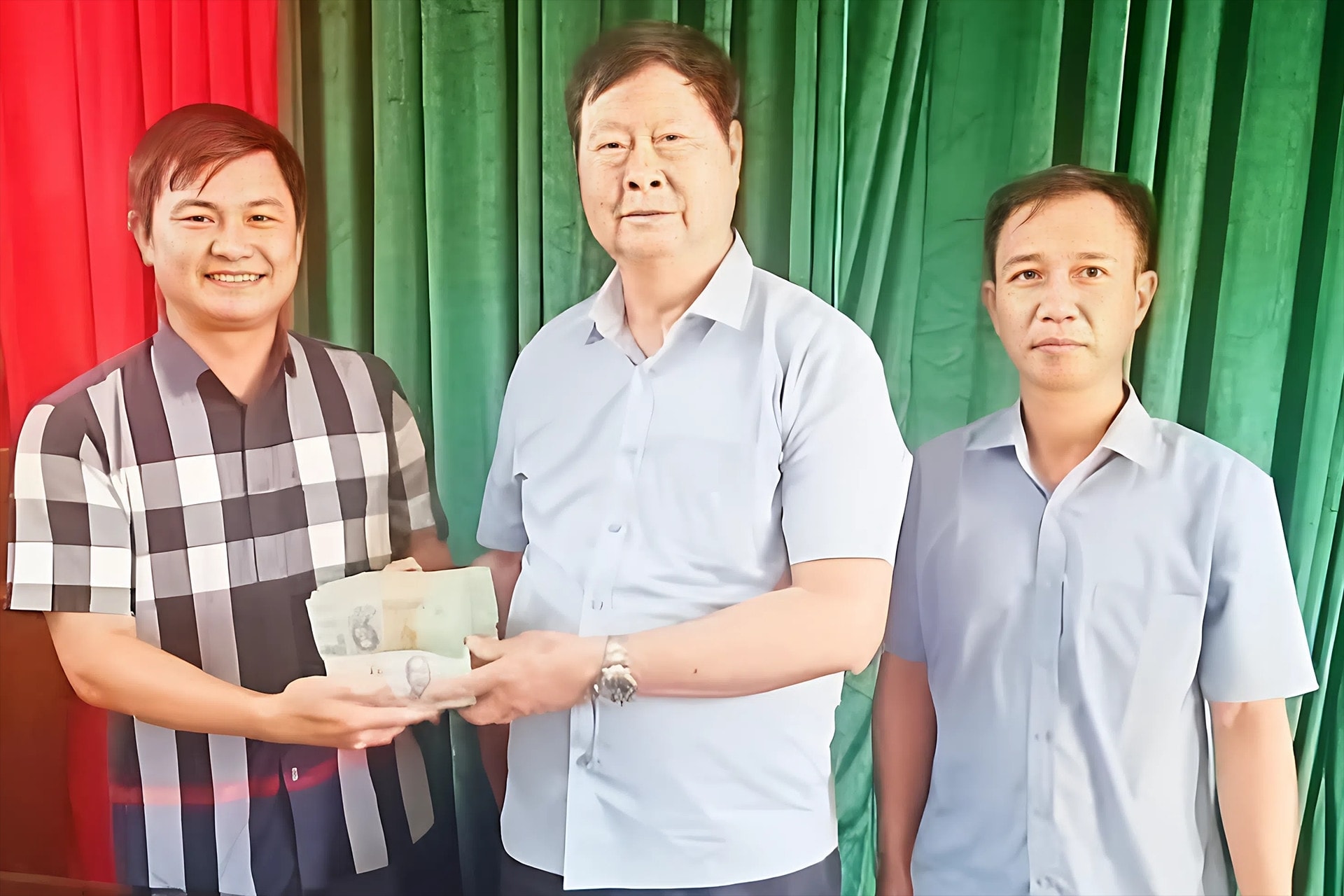 Thầy giáo Hưng (giữa) trao số tiền 1 tỷ đồng ủng hộ người dân cho đại diện chính quyền địa phương.