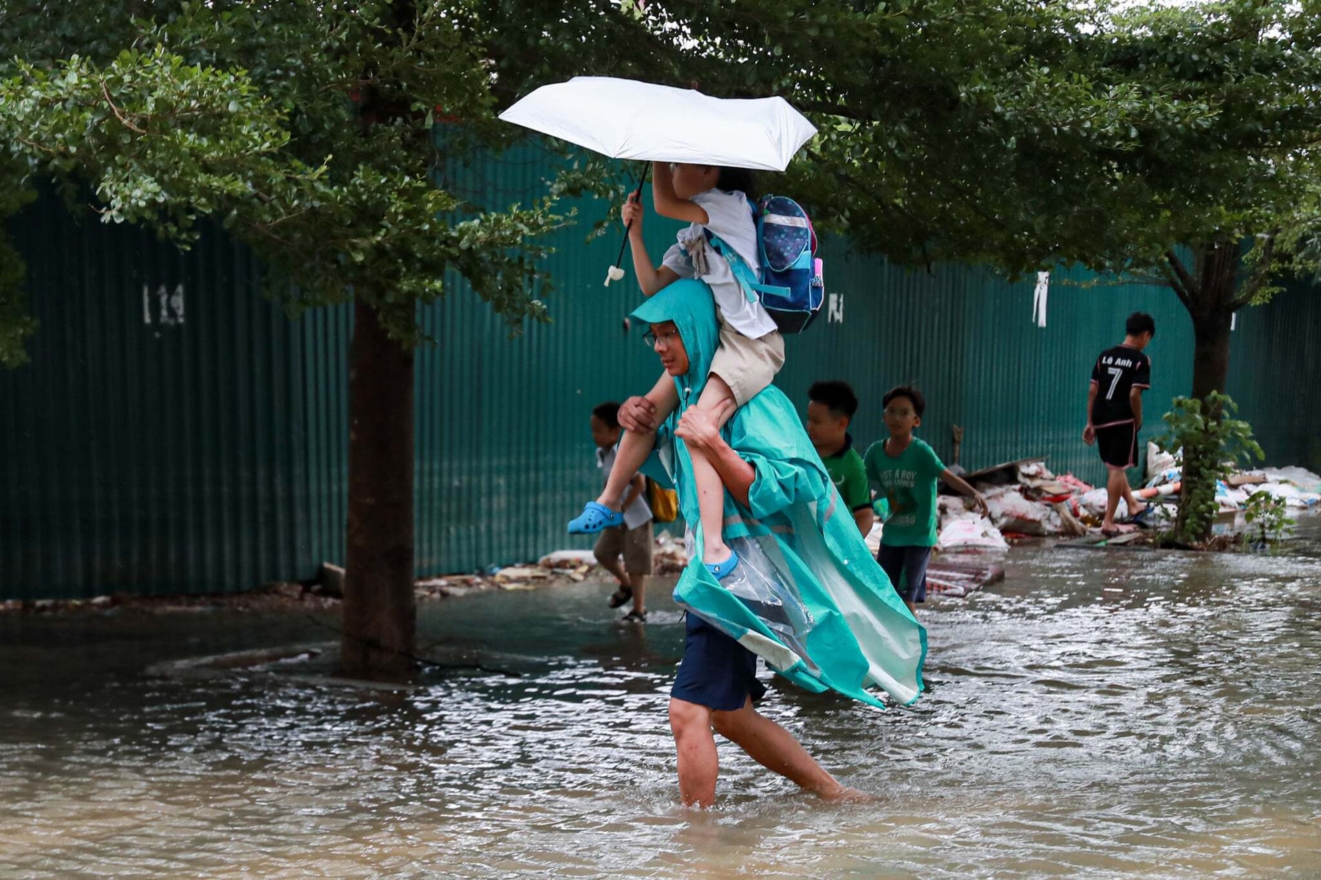 Mưa lớn sau bão số 10, phụ huynh khó khăn trong việc đưa đón con. (Ảnh: Minh Đức)