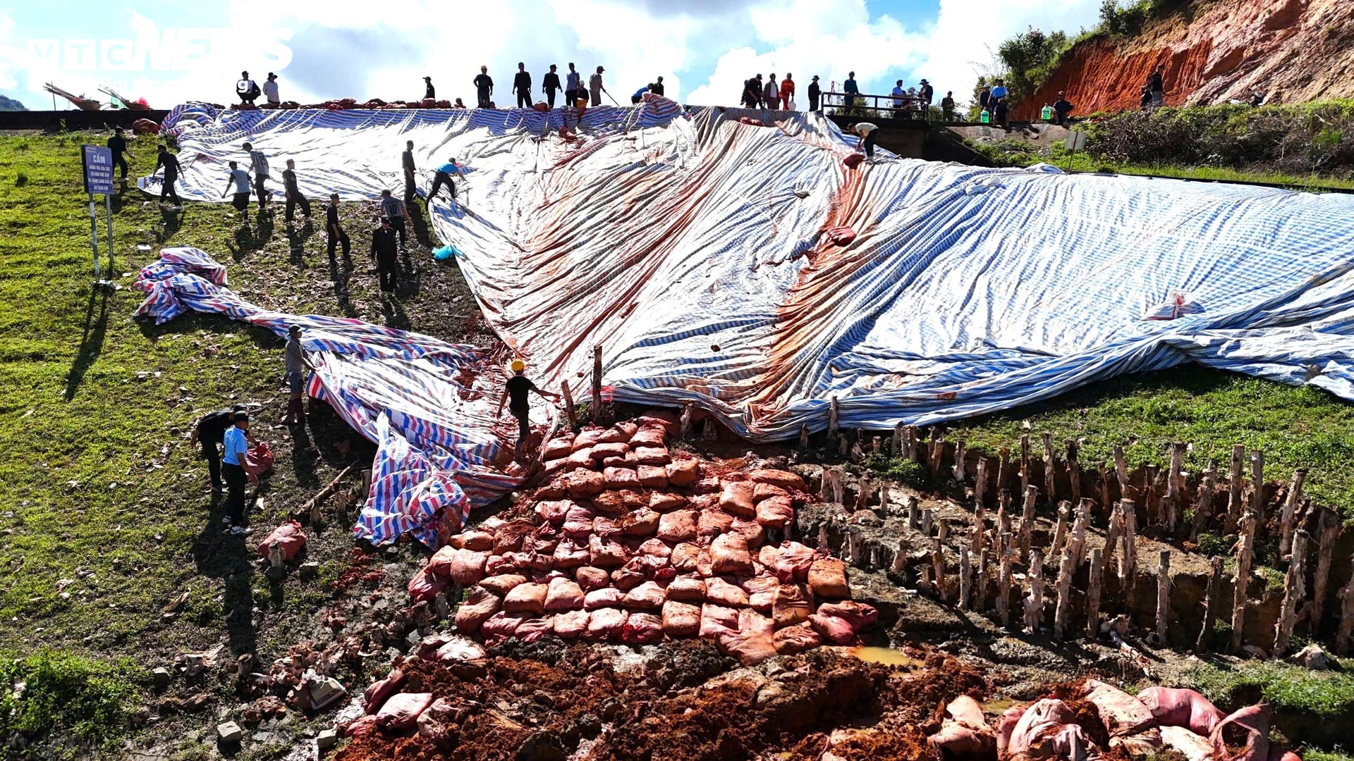 Lực lượng chức năng đắp đất, gia cố chân đập hồ Cay An.