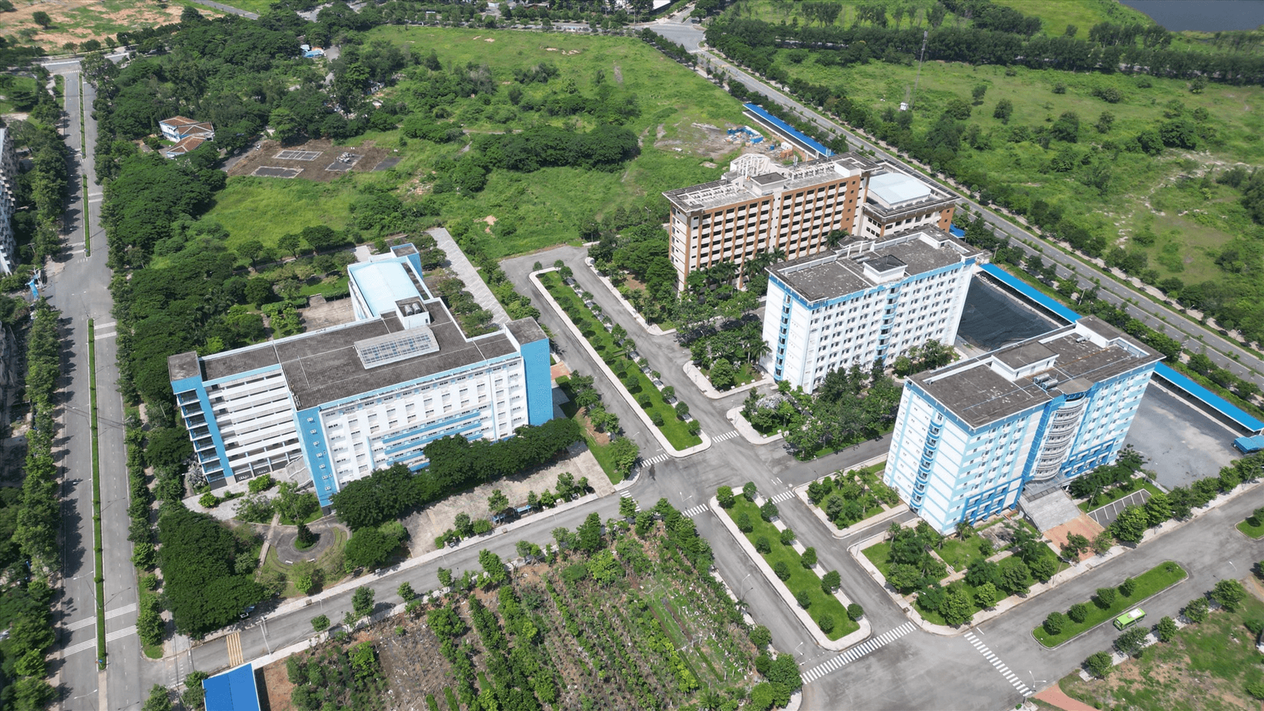 Trường Đại học Bách khoa TP.HCM gồm những tòa nhà màu xann, cạnh Ký túc xá khu A của Đại học Quốc gia TP.HCM.