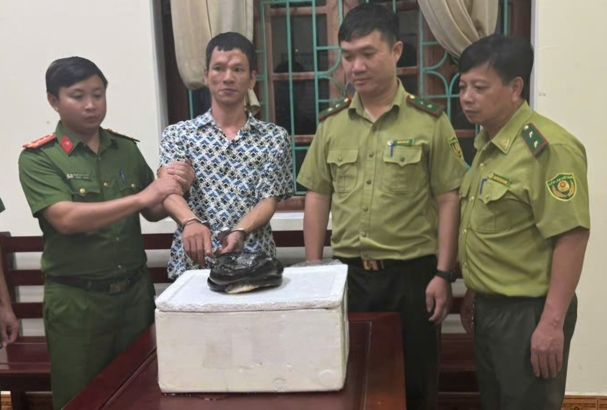Nguyễn Đình Huy cùng cá thể rắn hổ chúa quý hiếm bị lực lượng chức năng phát hiện, thu giữ.