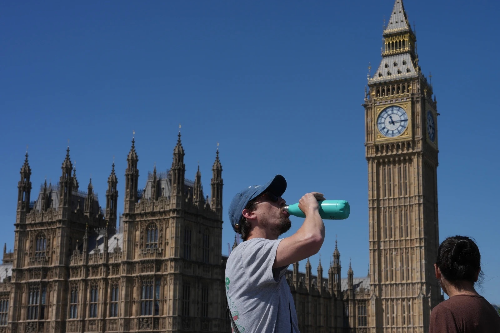 Một người đàn ông uống nước bên ngoài Cung điện Westminster ở London, Anh ngày 26/5/2026, khi nước này trải qua đợt nắng nóng kỷ lục. (Ảnh: AP/Kin Cheung)