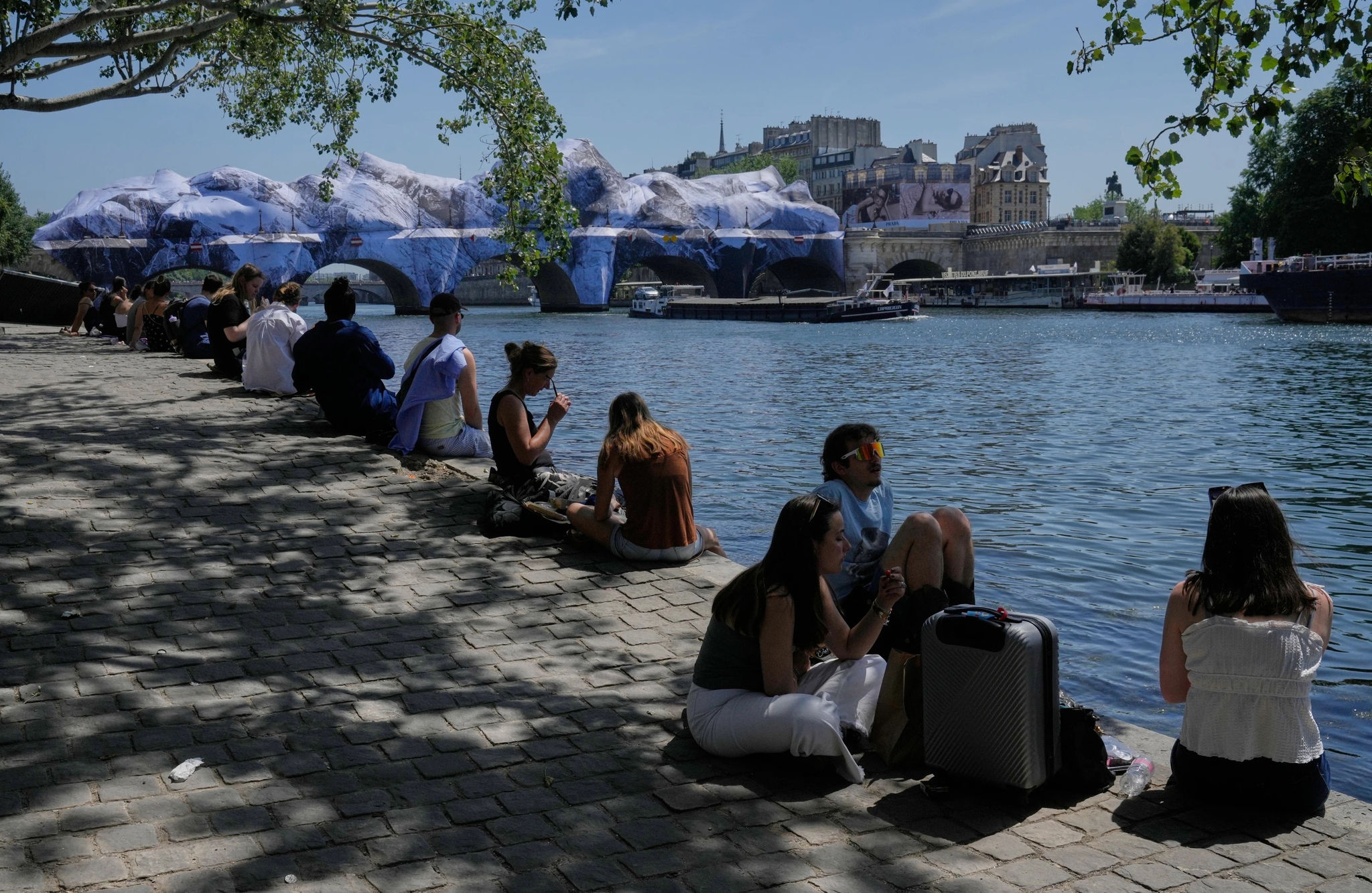 Người dân tìm cách tránh nóng dọc bờ sông Seine ở Paris, Pháp ngày 25/5/2026. (Ảnh: AP/Michel Euler)