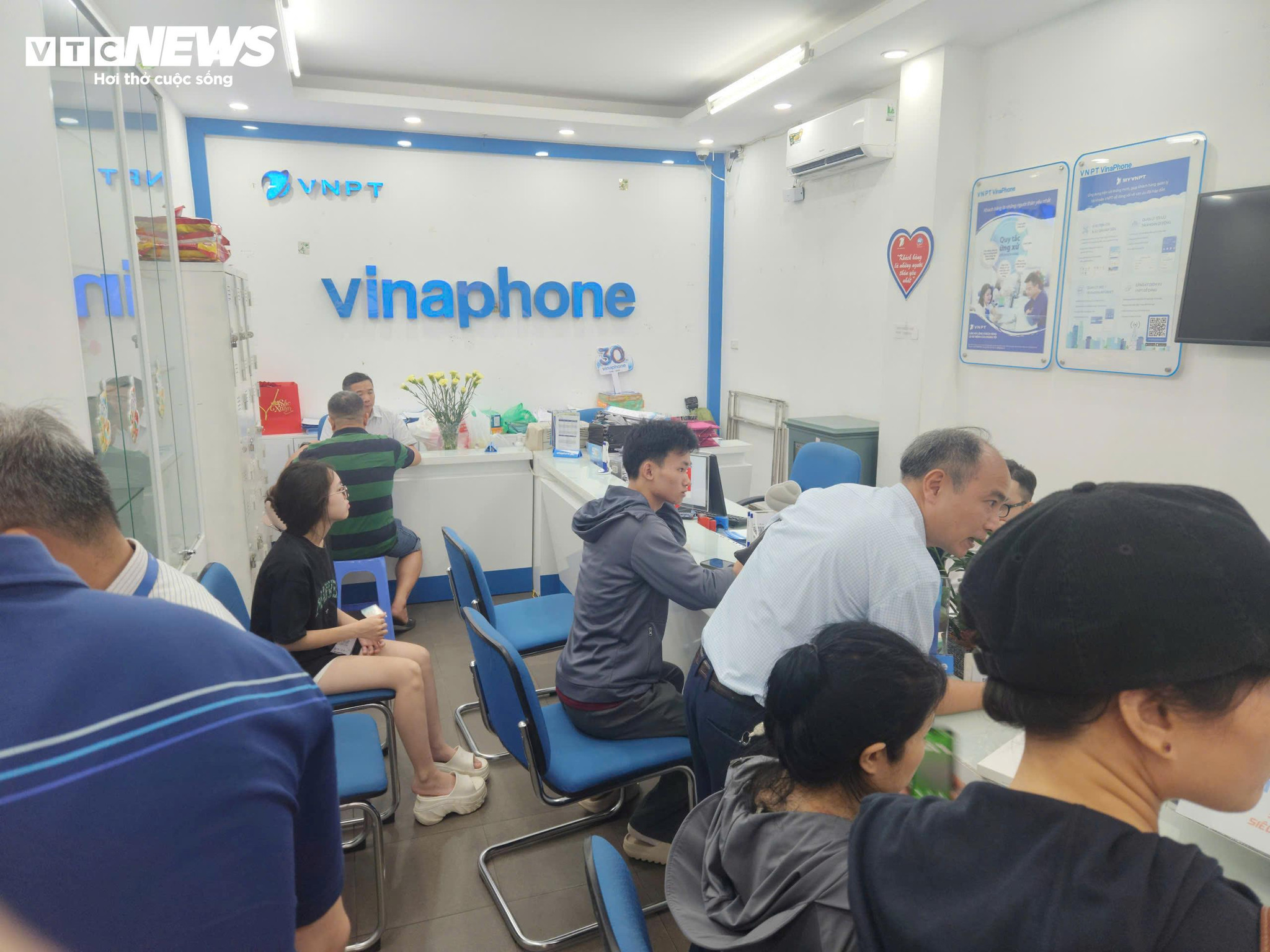 Khách hàng đến làm xác thực thuê bao tại điểm giao dịch của VinaPhone sáng ngày 15/6. (Ảnh: Minh Hoàn)