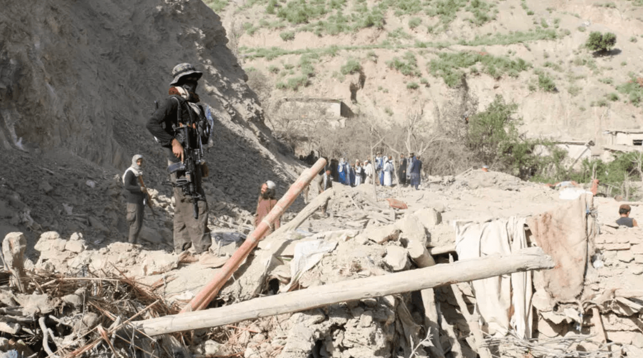Một thành viên an ninh Taliban đứng trên đống đổ nát của một ngôi nhà sau cuộc không kích mà Taliban cho rằng do Pakistan thực hiện vào ngày 10/6 năm 2026. © Reuters