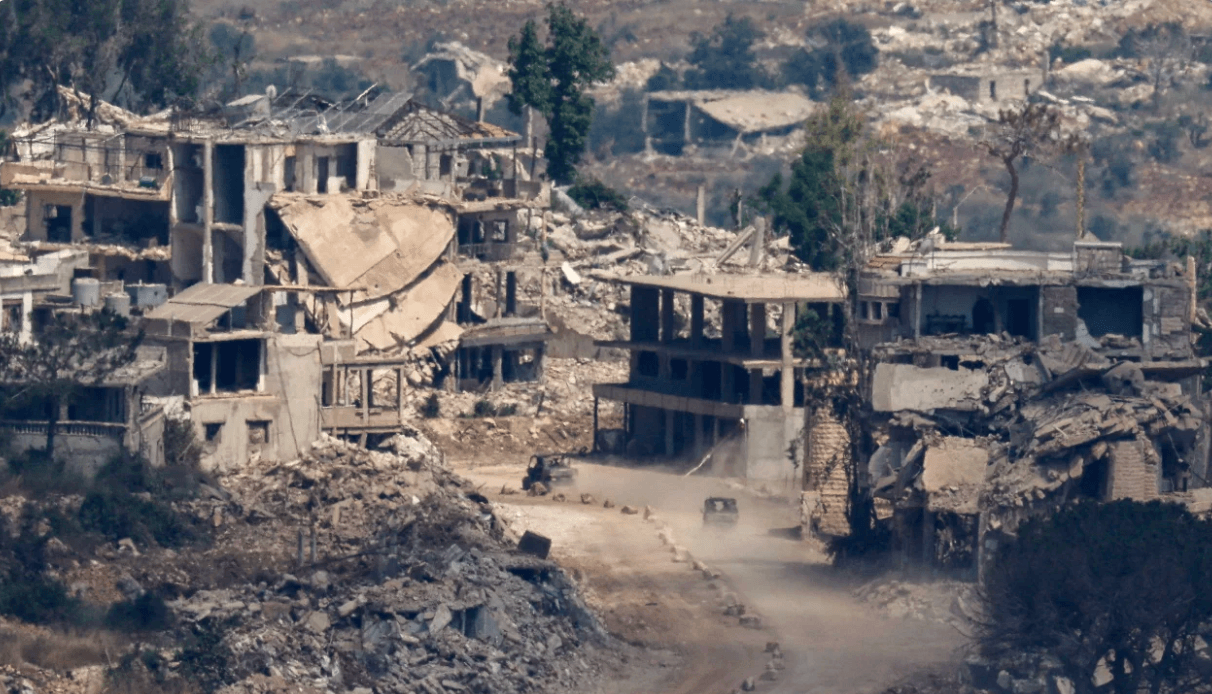 Phương tiện quân sự của Israel di chuyển giữa những tòa nhà bị phá hủy ở Lebanon. (Ảnh: Reuters)