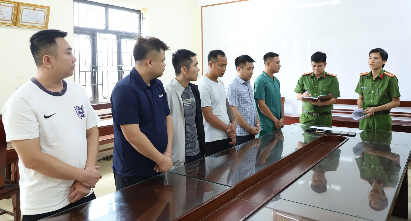 Các bị can trong đường dây cá độ bóng đá hơn 900 tỷ đồng tại cơ quan công an. (Ảnh: Công an Ninh Bình).
