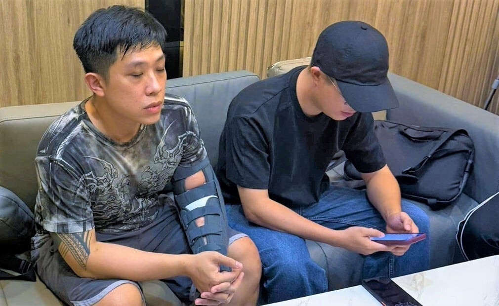 Bị can Vũ Quang Huy (tay có hình xăm) tại cơ quan công an. (Ảnh: Công an cung cấp)