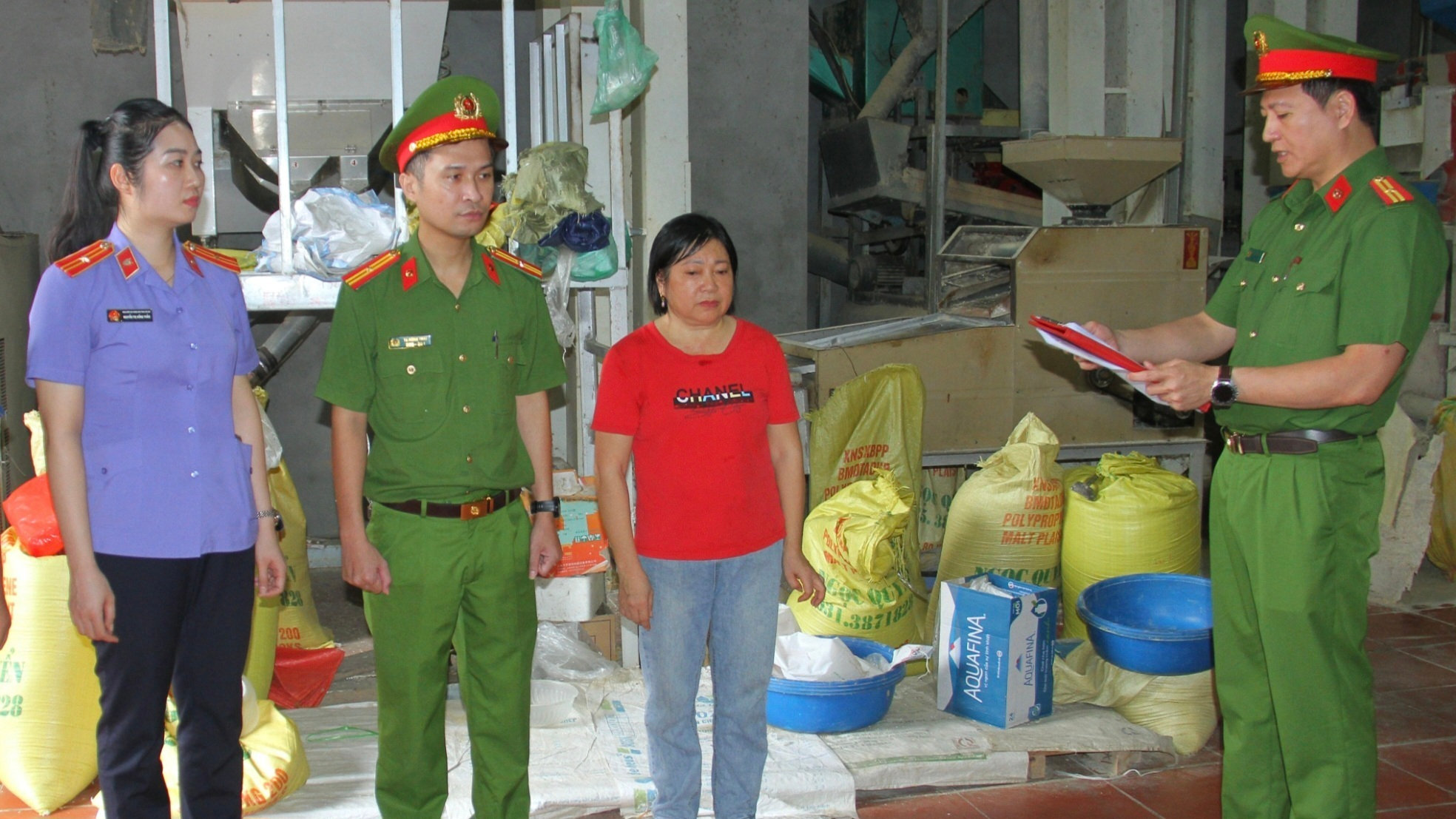 Cảnh sát thi hành các quyết định tố tụng với Phan Thị Lan (áo đỏ). (Ảnh: Công an tỉnh Lào Cai)