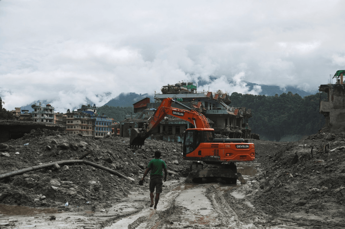 Máy xúc dọn sạch con đường lầy lội sau trận lũ quét và sạt lở đất ở Nepal. (Ảnh: Reuters)