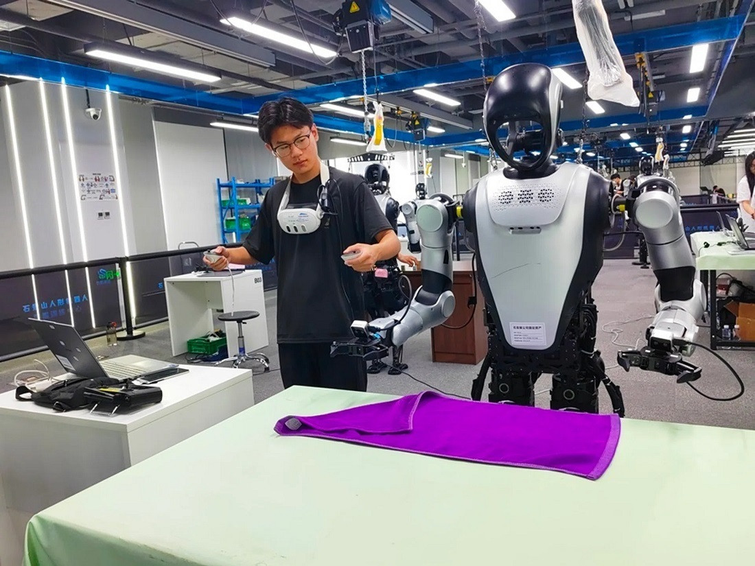 Chuyên gia huấn luyện robot cách gấp khăn tại Trung tâm đào tạo dữ liệu robot hình người Thạch Cảnh Sơn. (Ảnh: SPH Media )