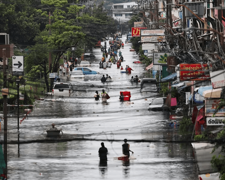 Người dân lội qua khu vực bị ngập lụt ở Bangkok, Thái Lan. (Ảnh: Reuters)