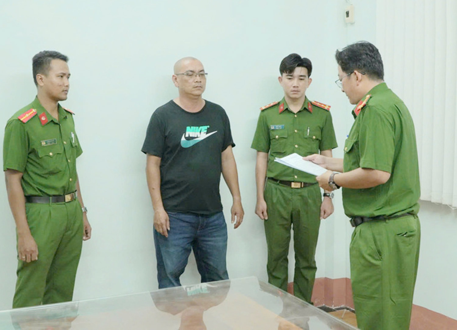 Chủ trại hòm Nhật Tâm nghe cơ quan điều tra đọc lệnh bắt tạm giam. (Ảnh: Đức Trung)