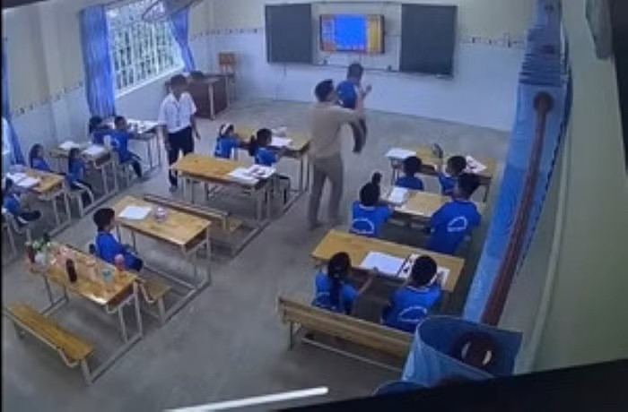 Hình ảnh người dạy tiếng Anh túm cổ một học sinh đưa ra khỏi lớp ở Trường Phổ thông Việt - Hoa. (Ảnh: Cắt từ video)